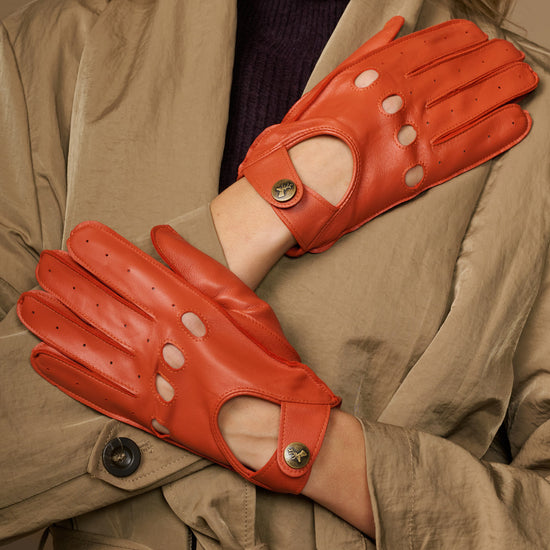 Women's orange lambskin driving gloves, perforated fingertips and snap-button wrist