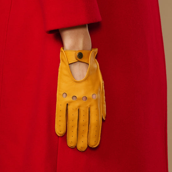 Yellow lambskin glove with oval cutout, button tab cuff and stitched fingers