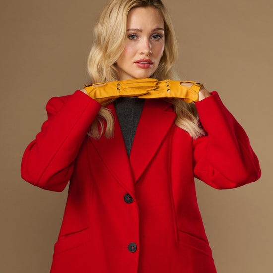 Yellow lambskin gloves worn together, touchscreen fingertips and cuff buttons