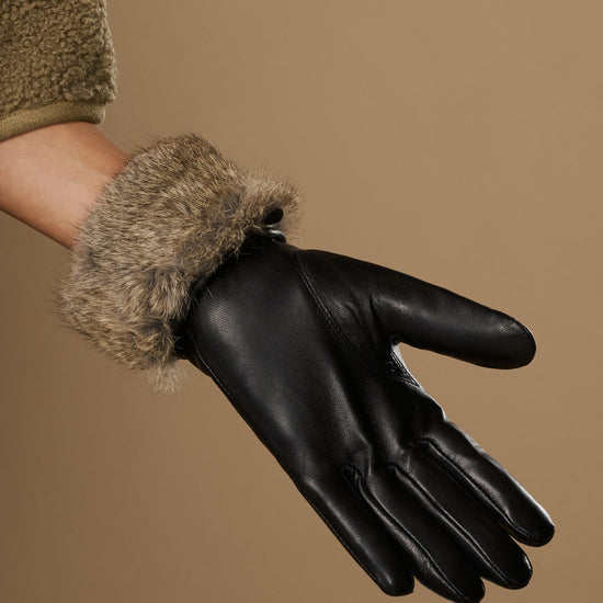 Black leather gloves with plush gray fur lining and touchscreen finger tips