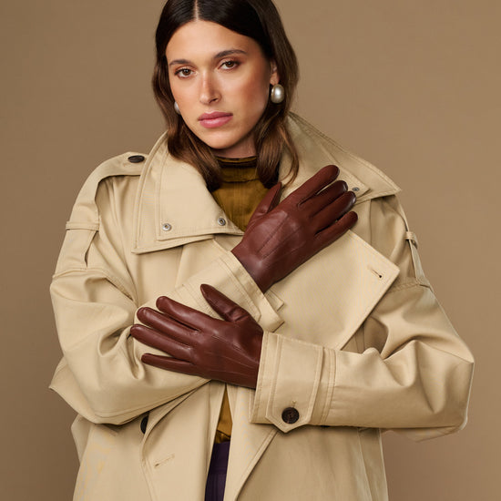 Woman wearing extra-long brown leather gloves with rabbit-fur lined cuffs