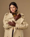 Woman wearing extra-long brown leather gloves with rabbit-fur lined cuffs