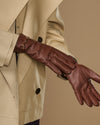 Dark brown leather glove with gold-tone buckle strap and stitched finger seams