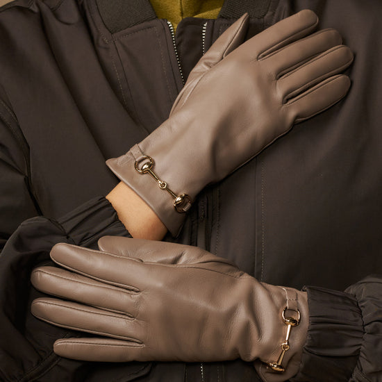 Taupe leather gloves with gold-tone buckles and smooth stitched finger design