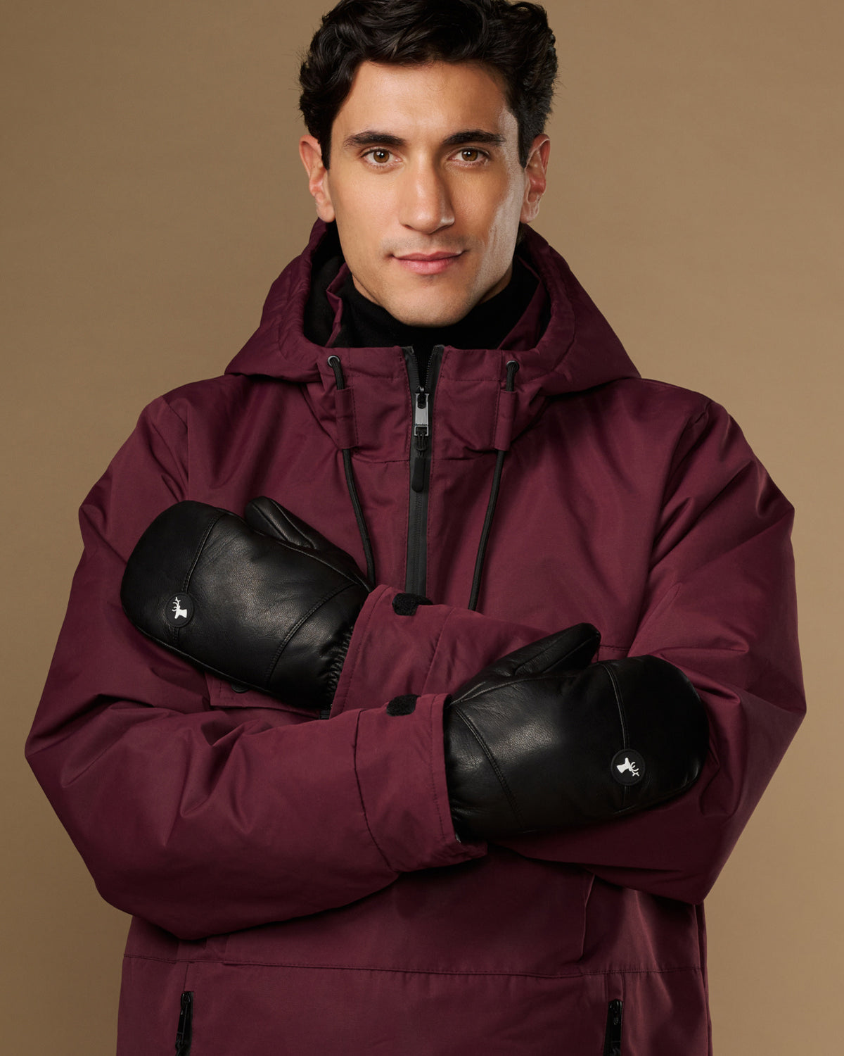 Black leather men's mittens worn crossed over the chest.