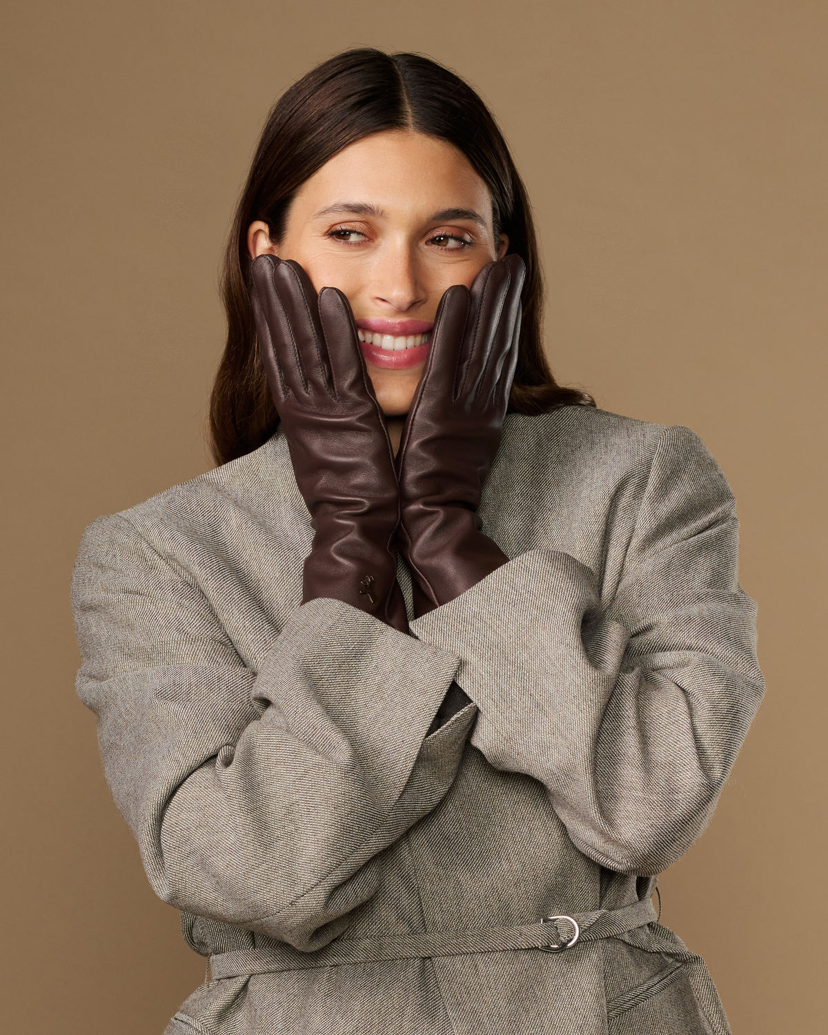 Long dark brown leather gloves held together in front