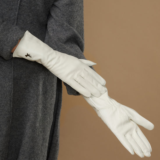 White leather gloves, side view with logo on cuff and smooth, fitted finish