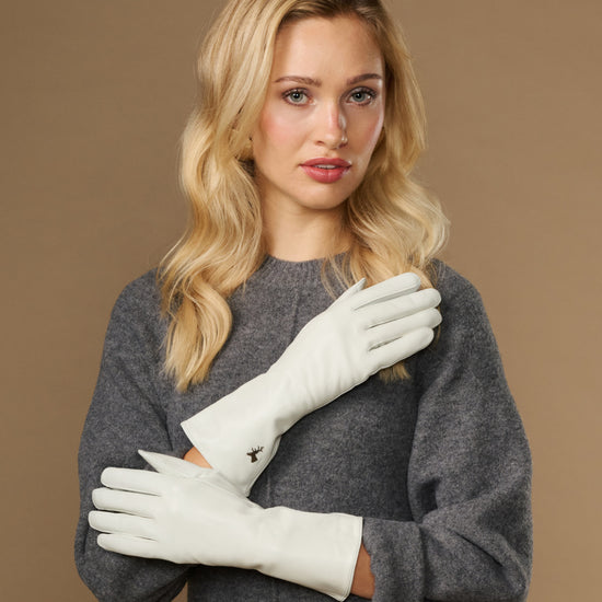 White long leather gloves worn, cuffs at wrists with stitched, clean design