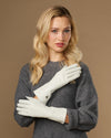 White long leather gloves worn, cuffs at wrists with stitched, clean design