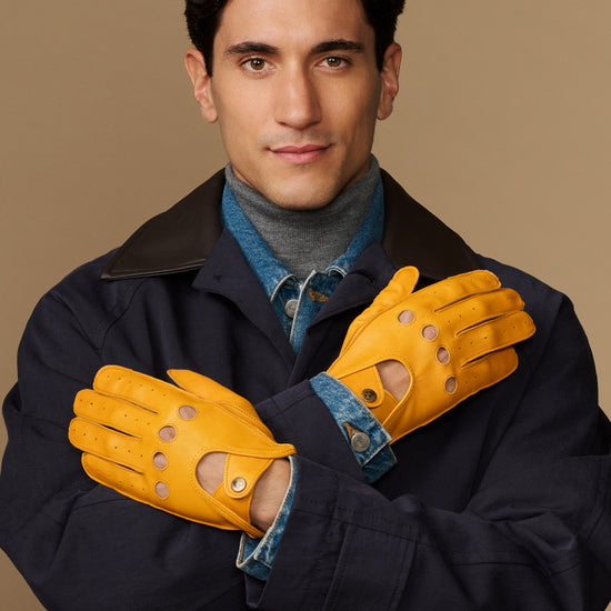 Pair of men's yellow lambskin driving gloves with denim lining and perforated knuckles