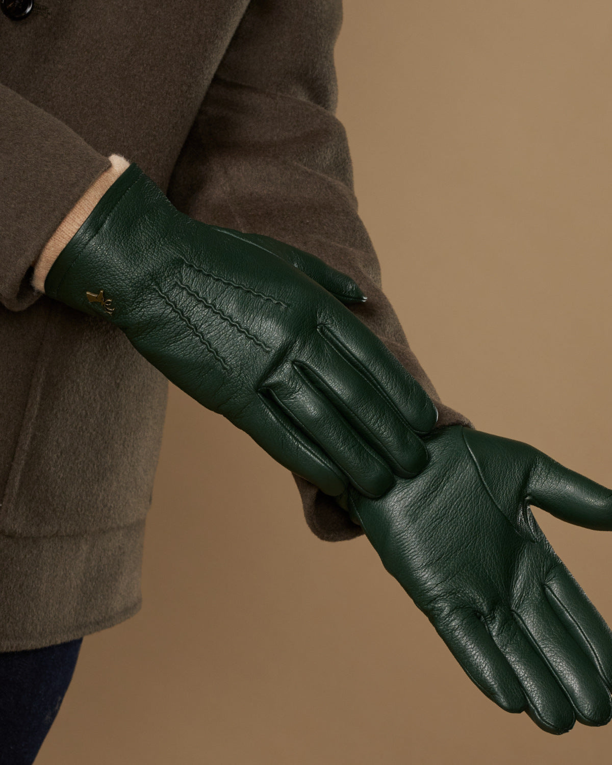 Men's dark green leather gloves with close-up finger seams and textured palm