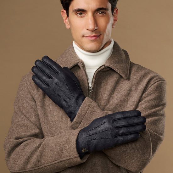 Men's navy goatskin leather gloves with wool lining, front view with hands crossed
