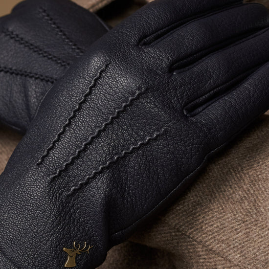 Men's navy leather gloves with wool lining, gold logo and detailed textured stitching
