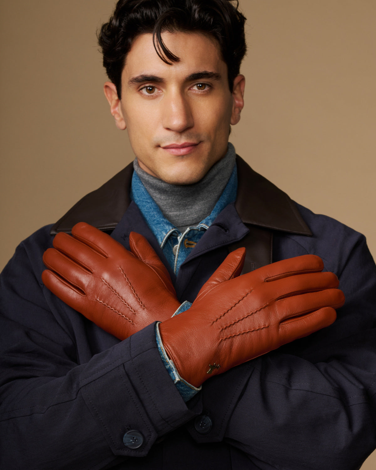Men's cognac goatskin gloves with blue lambswool lining, arms crossed