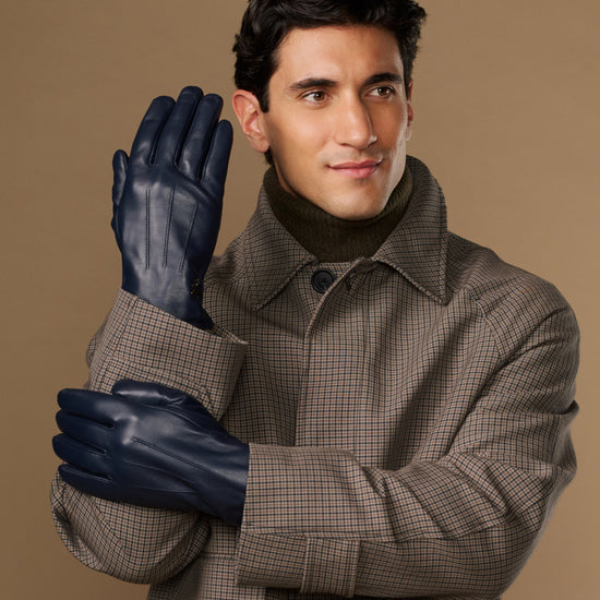 Navy leather gloves with stitched fingers, worn by a man in a plaid coat