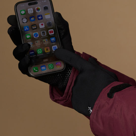 Black touchscreen-compatible activity gloves used to operate a phone