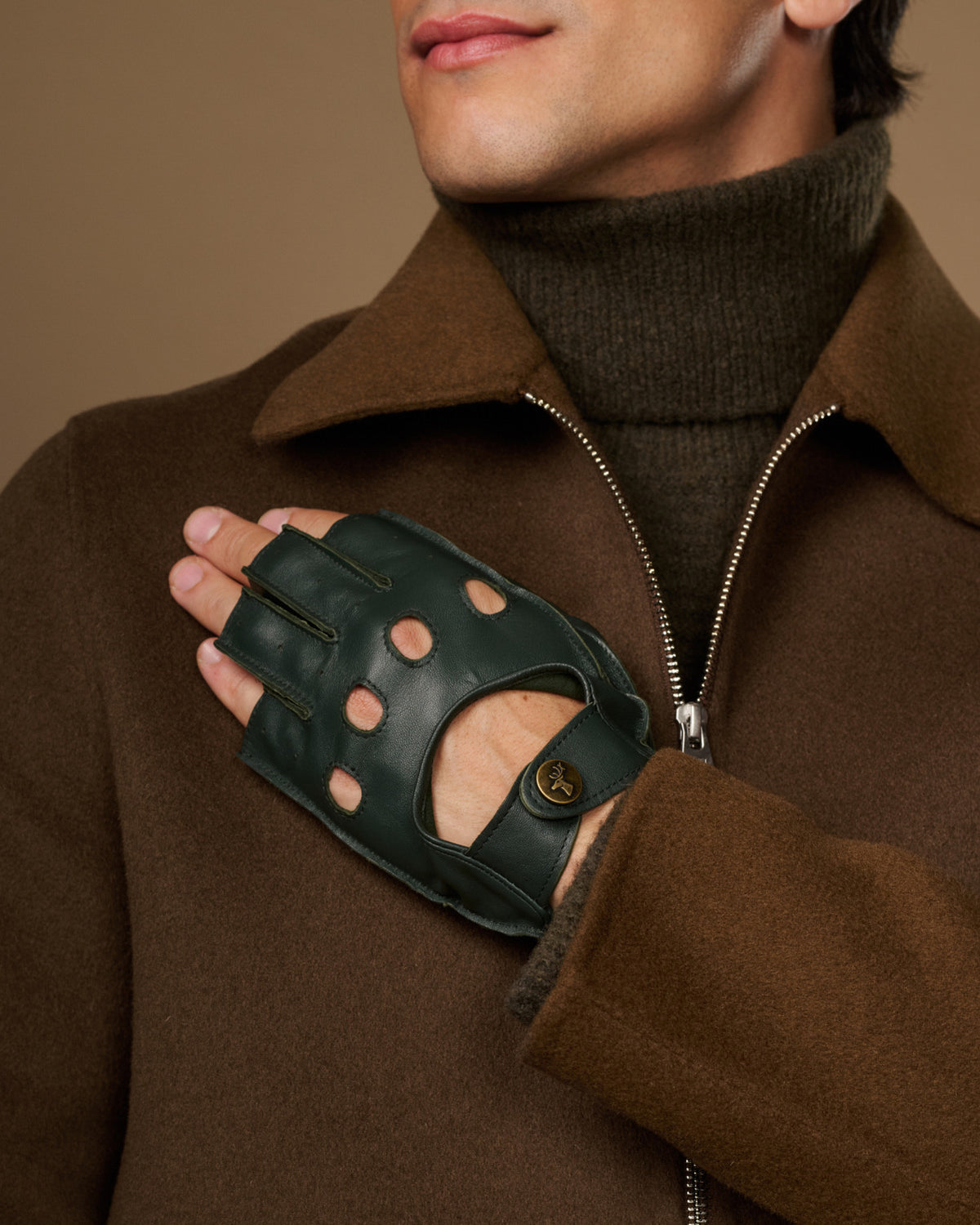 Dark green lambskin glove with fingerless tips, perforated knuckles, and a buttoned wrist strap