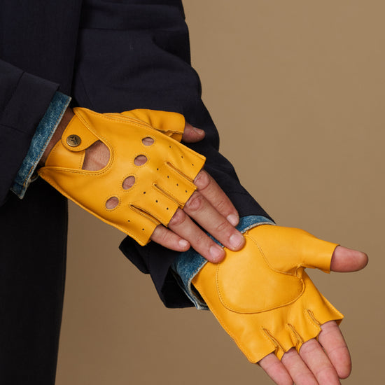 Yellow fingerless glove on open hand, stitched seams and knuckle perforations