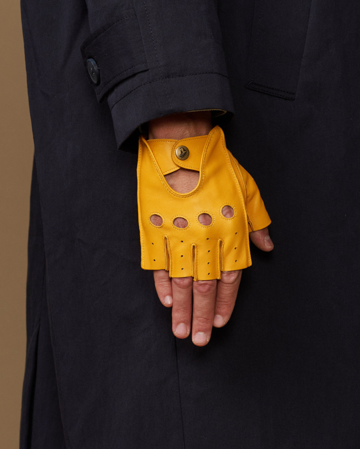 Yellow fingerless glove with snap wrist cuff, perforated finger and knuckle panels