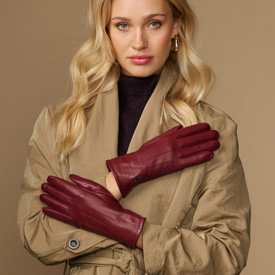 Bordeaux leather gloves with fleece-lined cuffs and stitched detailing across fingers
