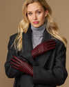 Women's black leather gloves with red and black checkered lining, worn with cuffs