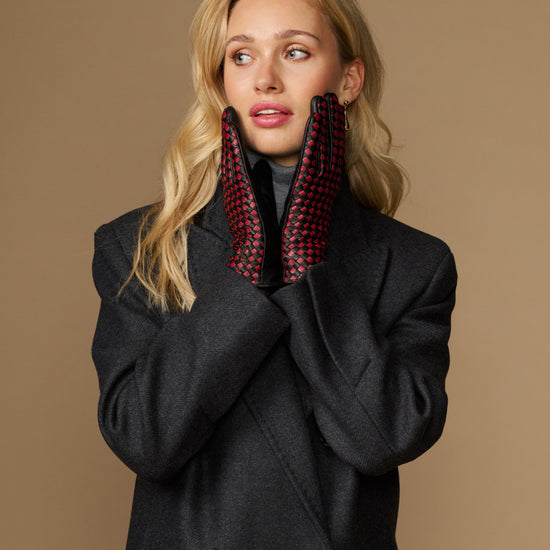 Women's black leather gloves with red-and-black checkered lining, worn at neckline