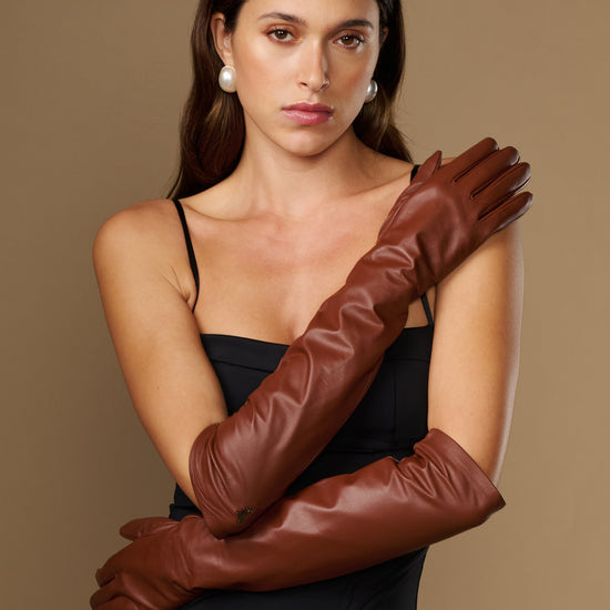 Chocolate brown leather elbow gloves worn close-up showing wrinkle-free texture