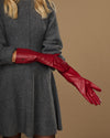 Red leather mid-forearm gloves shown in side profile with detailed stitched seams