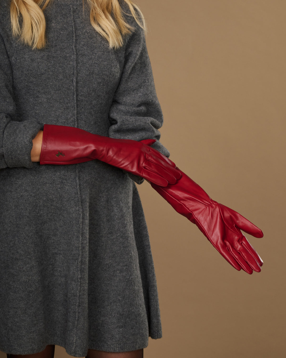 Red leather mid-forearm gloves shown in side profile with detailed stitched seams