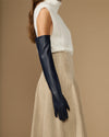 Navy leather opera gloves with long cuffs and silk lining, side view on the arm