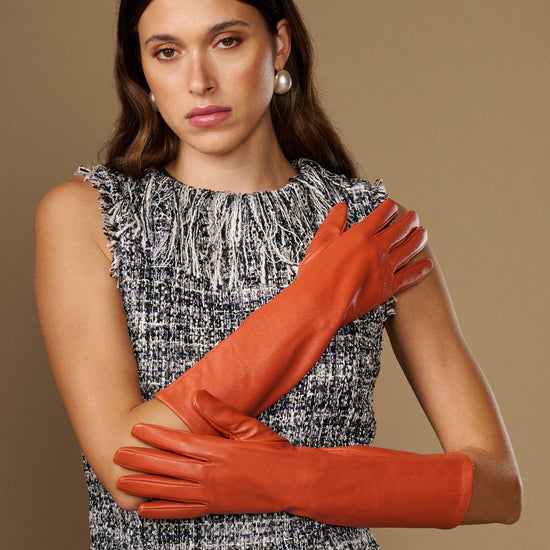 Women’s orange below-elbow leather gloves with smooth lambskin finish and wrist cuff