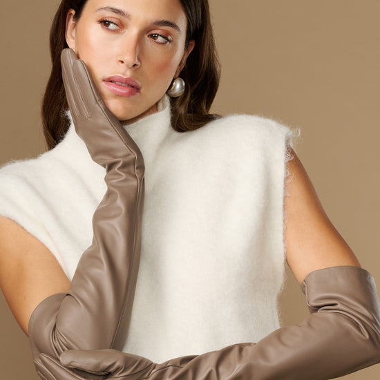 Close-up of taupe leather gloves showing long cuff and smooth knuckle area