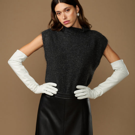 Women's white leather gloves with long cuffs, held together at waist