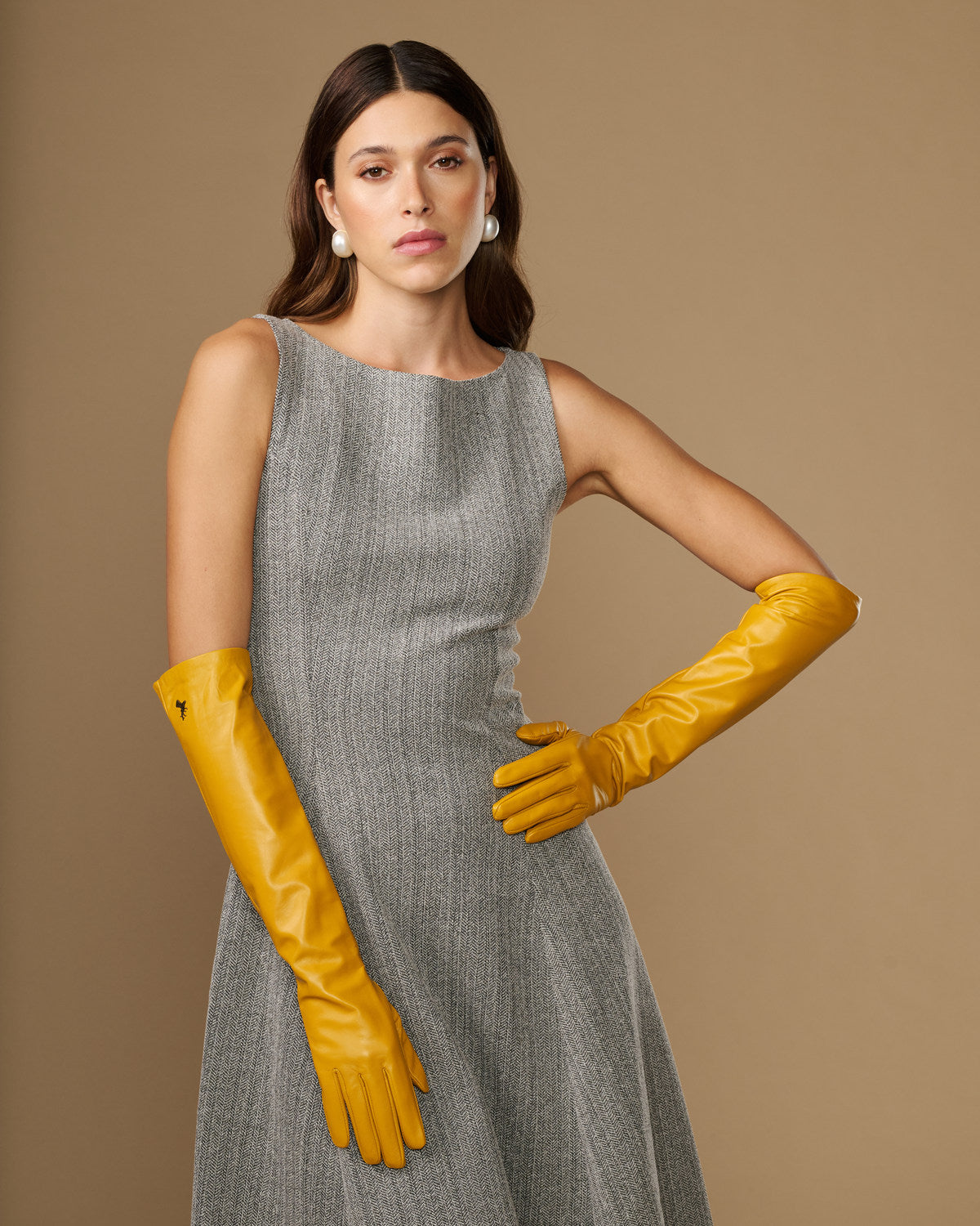 Yellow leather elbow gloves with long cuffs and finger shaping, worn with dress