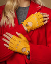 Yellow fingerless leather driving gloves with perforated knuckle detail and thumb opening