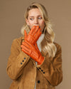 Orange leather gloves at face with stitched fingers and soft lined cuffs, nose and mouth covered